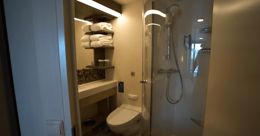 Spacious and well-stocked bathroom in an Ocean-View family room on Royal Caribbean's Spectrum of the Seas, featuring towels, soap, and essential amenities.