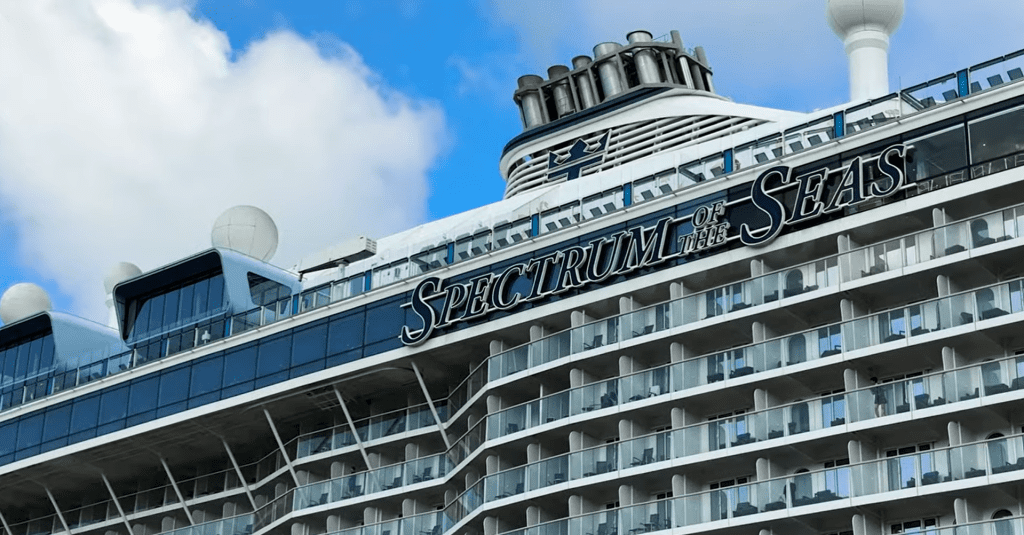 Royal Caribbean's Spectrum of the Seas docked at port with blue skies in the background.