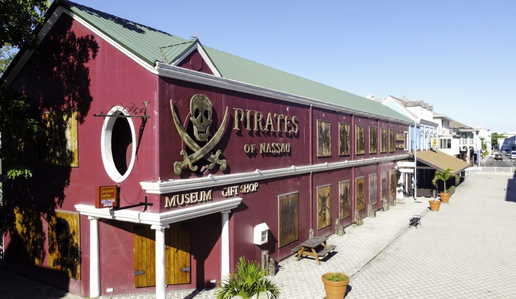 Entrance to the Pirates of Nassau Museum, featuring a life-sized pirate statue and themed decor, inviting visitors to explore the golden age of piracy.