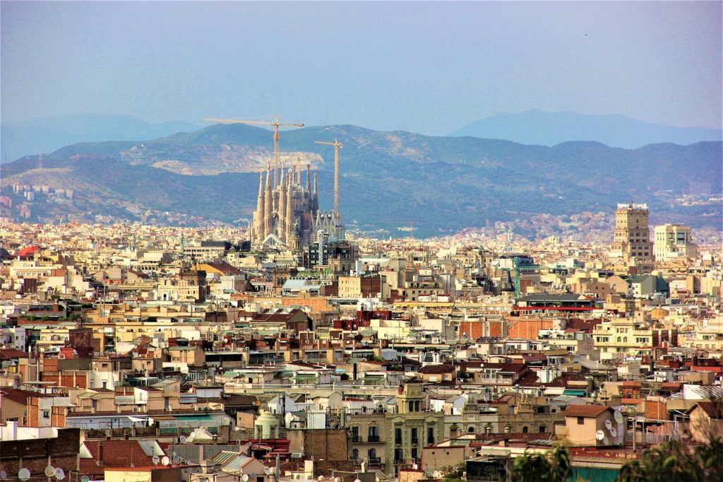 La Sagrada Família towering over surrounding Spanish buildings, highlighting its prominence in the Barcelona skyline.