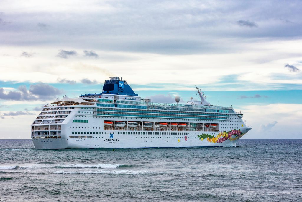 A majestic cruise ship sails near Puerto Plata, Dominican Republic, under a vibrant sky.