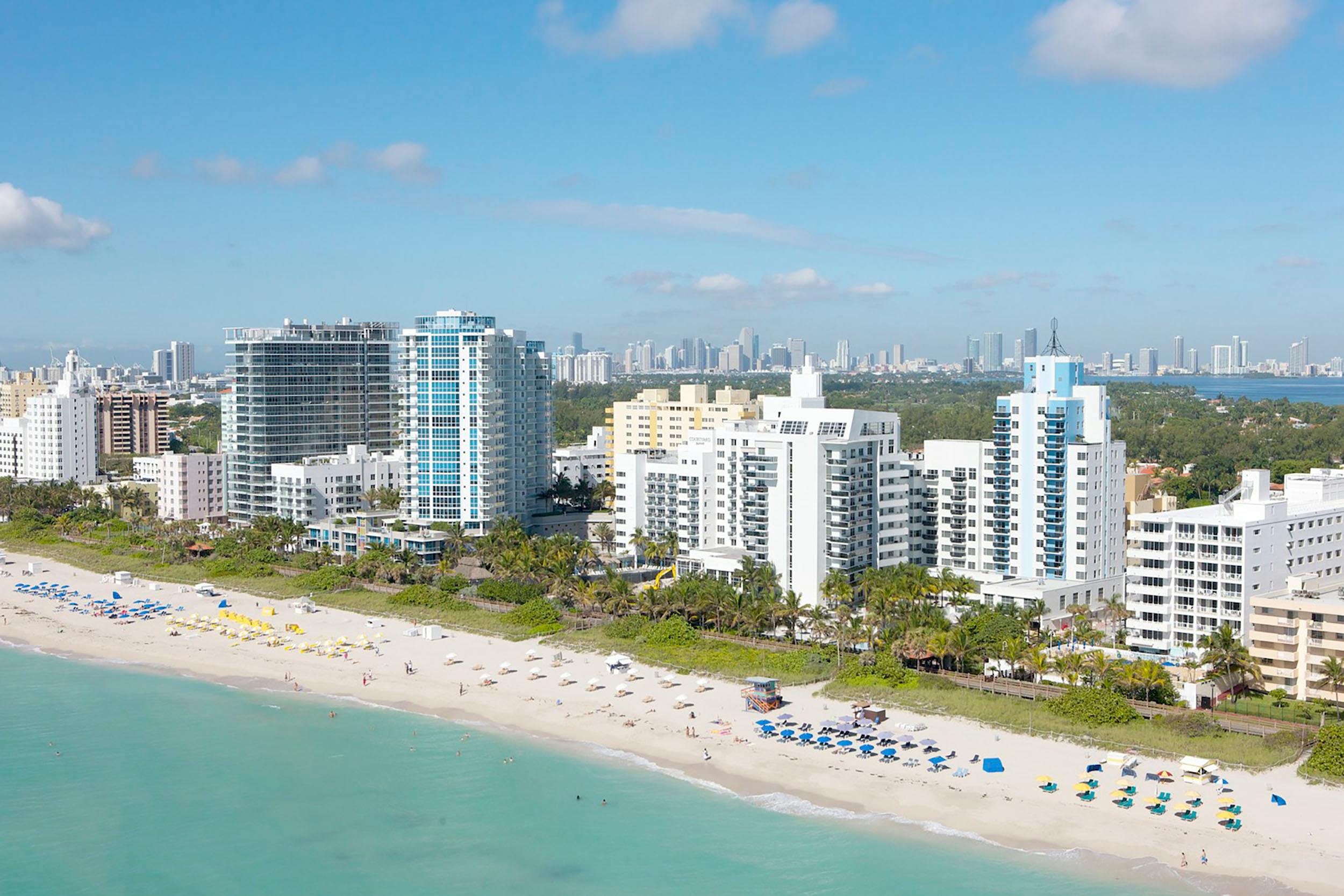 Aerial view of Miami's skyline featuring various hotels along the waterfront, showcasing the city's vibrant hospitality scene.