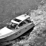 Elegant yacht cruising a river captured in a high contrast black and white photograph.