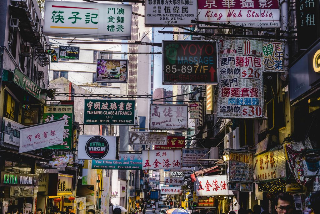 Vibrant urban street filled with numerous bright signs in Hong Kong, showcasing local businesses and culture.